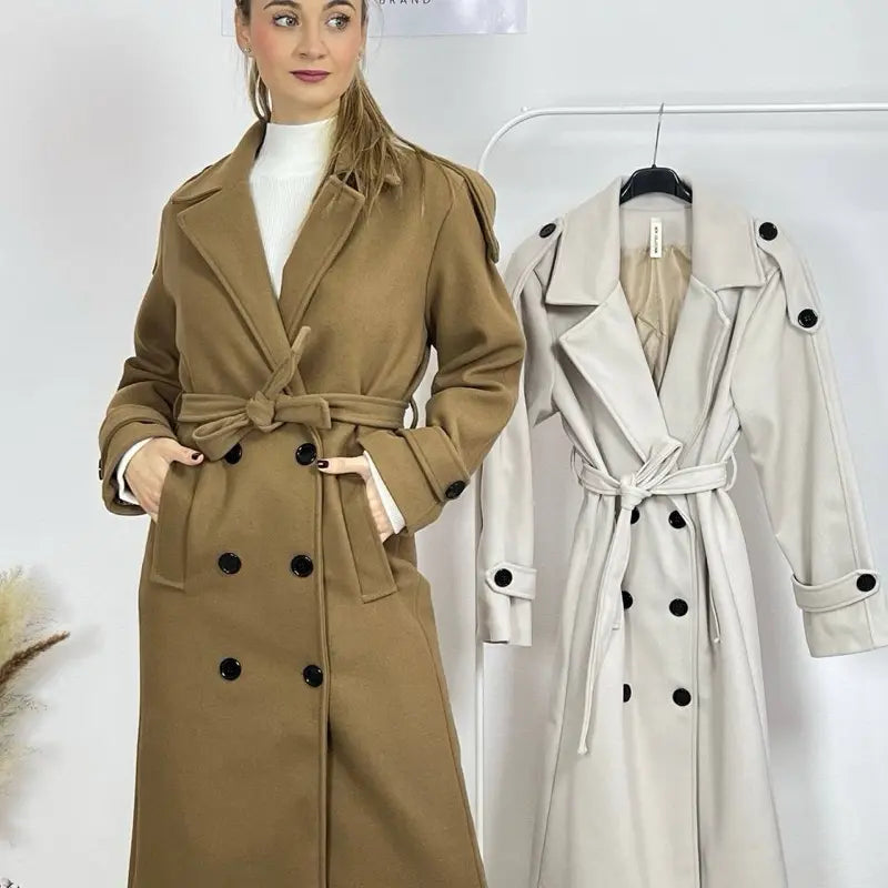 Ce manteau croisé présente une fermeture boutonnée, une ceinture intégrée et des poches pratiques, alliant élégance raffinée et praticité polyvalente.