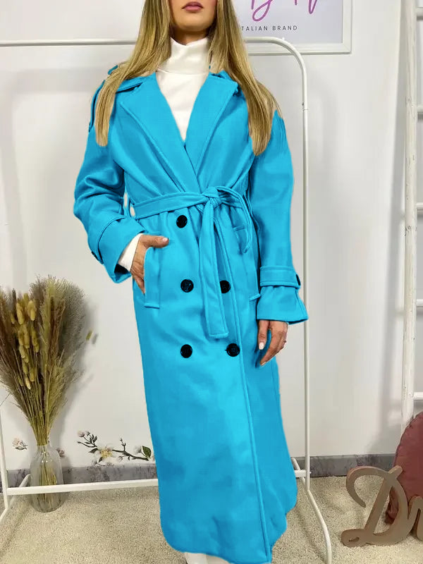 Ce manteau croisé présente une fermeture boutonnée, une ceinture intégrée et des poches pratiques, alliant élégance raffinée et praticité polyvalente.